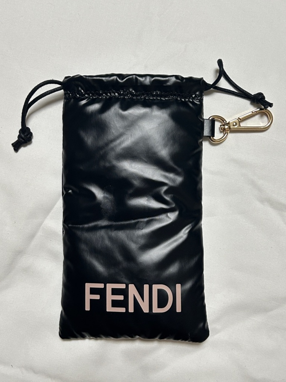 Fendi glossy black puffer sunglasses pouch featuring a gold-toned hardware clip